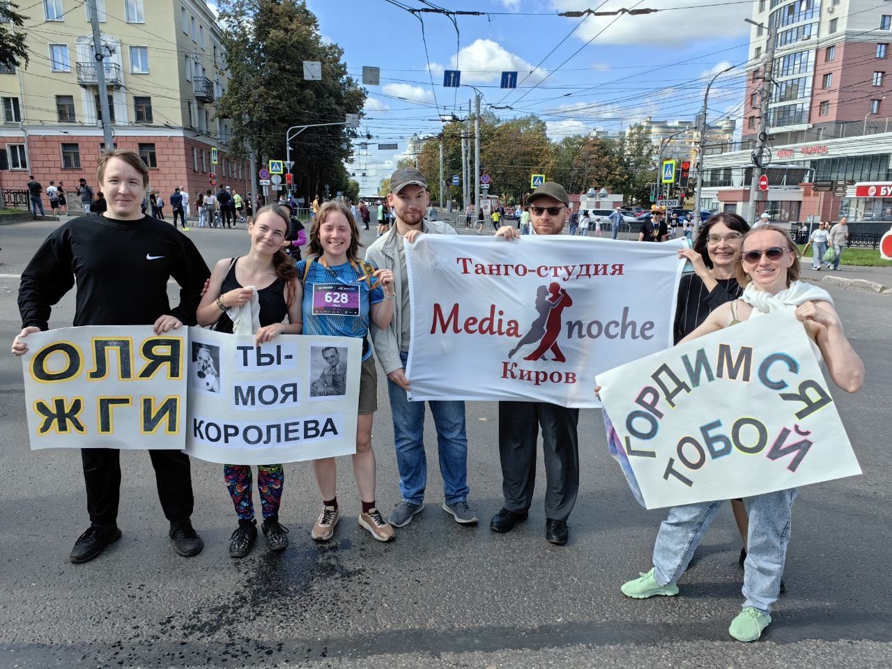 Команда студии на беговом марафоне с плакатами поддержки